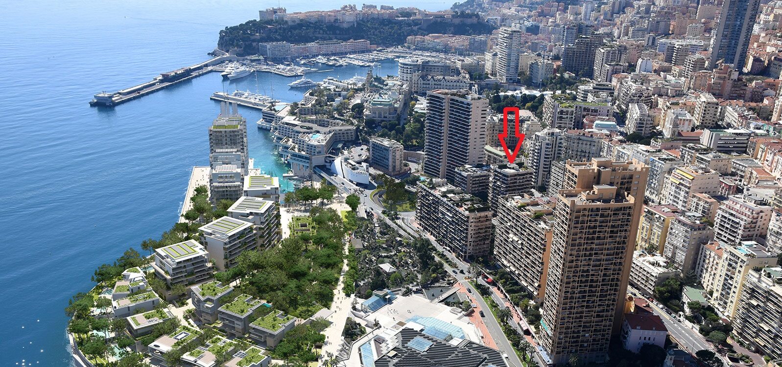 Les Acanthes nuilding marked with a red arrow in an aerial image of Portier Cove and Carré d'Or