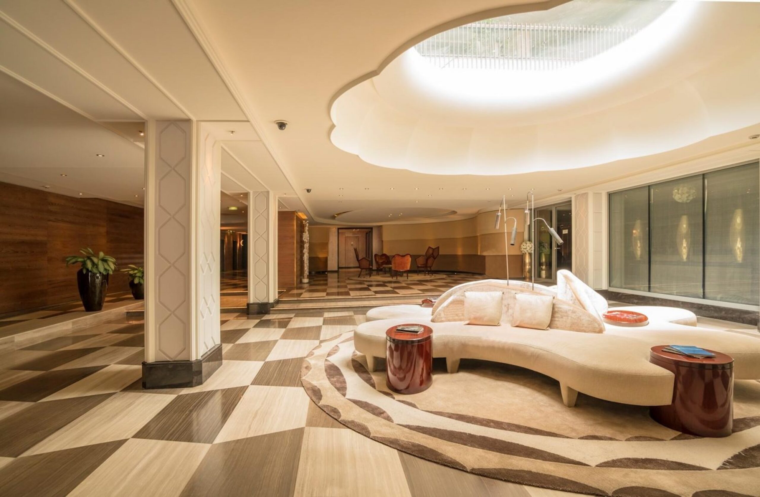 Lobby and concierge desk pictured in Le Mirabeau. White couch in a well-lit entrance area